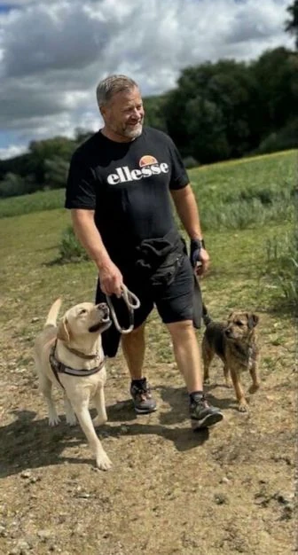 Mike mit zwei Hunden auf einem sonnigen Feldweg